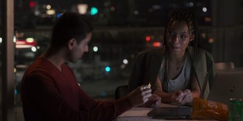 Movie still from “Sitting in Bars with Cake” (2023), directed by Trish Sie – A man and a woman sitting in front of a computer; Medium shot, Over the shoulder angle