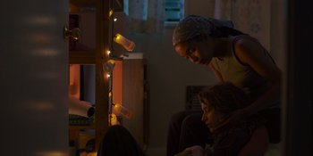 Movie still from “Sitting in Bars with Cake” (2023), directed by Trish Sie – A couple of people that are sitting on the floor; Medium shot, Low angle