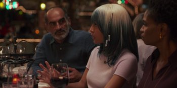 Movie still from “Sitting in Bars with Cake” (2023), directed by Trish Sie – A woman sitting next to a man at a table with a glass of red wine; Medium shot, Over the shoulder angle