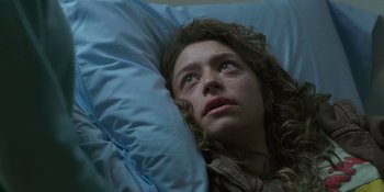 Movie still from “Sitting in Bars with Cake” (2023), directed by Trish Sie – A woman laying in a bed looking up at the sky; Close Up shot, Overhead angle