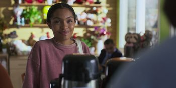 Movie still from “Sitting in Bars with Cake” (2023), directed by Trish Sie – A young woman standing in front of an espresso machine; Close Up shot, Over the shoulder angle