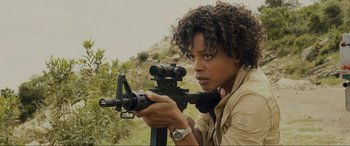 Movie still from “Skyfall” (2012), directed by Sam Mendes – A woman is holding a rifle and aiming it; Close Up shot, High angle