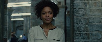 Movie still from “Skyfall” (2012), directed by Sam Mendes – A black woman with curly hair wearing a white shirt; Close Up shot, Low angle