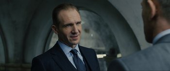 Movie still from “Skyfall” (2012), directed by Sam Mendes – A person wearing a suit and tie; Close Up shot, Over the shoulder angle