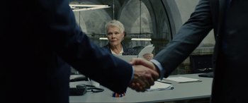 Movie still from “Skyfall” (2012), directed by Sam Mendes – Two people shaking hands over a table; Close Up shot, Over the shoulder angle