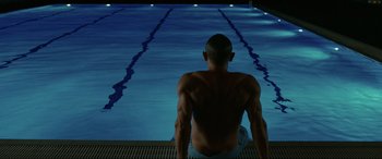 Movie still from “Skyfall” (2012), directed by Sam Mendes – A man sitting on the edge of a swimming pool; Medium shot, High angle