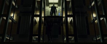Movie still from “Skyfall” (2012), directed by Sam Mendes – A man in a suit is standing in a stairwell; Wide shot, Low angle