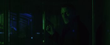 Movie still from “Skyfall” (2012), directed by Sam Mendes – A man holding a gun while standing in a dark room; Close Up shot, Low angle