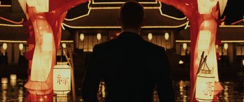 Movie still from “Skyfall” (2012), directed by Sam Mendes – A man in a black suit standing under an umbrella; Medium shot, Low angle