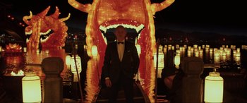 Movie still from “Skyfall” (2012), directed by Sam Mendes – A man standing in front of an illuminated dragon; Medium shot, Low angle