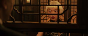 A woman with blonde hair looking through a window