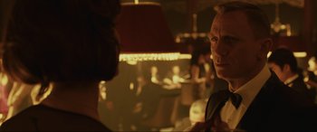 Movie still from “Skyfall” (2012), directed by Sam Mendes – Two people are talking in a dimly - lit room; Close Up shot, Over the shoulder angle