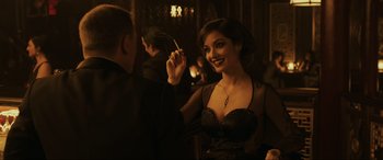 A woman in a black dress holding a cigarette holder