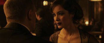 Movie still from “Skyfall” (2012), directed by Sam Mendes – A beautiful woman wearing a necklace and earrings; Close Up shot, Over the shoulder angle