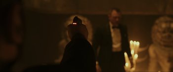 Movie still from “Skyfall” (2012), directed by Sam Mendes – A man is holding a gun up to his face; Close Up shot, Over the shoulder angle