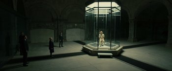 Movie still from “Skyfall” (2012), directed by Sam Mendes – A man sitting in a glass box in a building; Wide shot, High angle