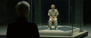 Movie still from “Skyfall” (2012), directed by Sam Mendes – A man sitting on a step in front of a mirror; Medium shot, Over the shoulder angle