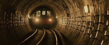 Movie still from “Skyfall” (2012), directed by Sam Mendes – A train is traveling down the tracks in a tunnel; Extreme Wide shot, High angle