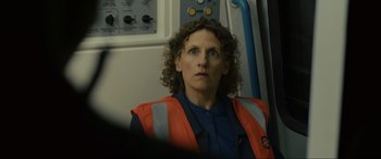 Movie still from “Skyfall” (2012), directed by Sam Mendes – A woman in an orange vest sitting on a train; Close Up shot, Over the shoulder angle