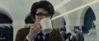 Movie still from “Skyfall” (2012), directed by Sam Mendes – A man with glasses is drinking from a mug; Close Up shot, Over the shoulder angle