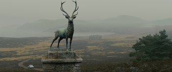Movie still from “Skyfall” (2012), directed by Sam Mendes – A statue of a deer stands on top of a stone wall; Extreme Wide shot, Low angle