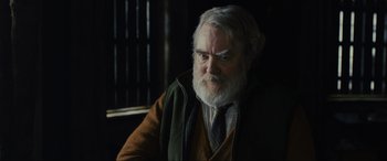 Movie still from “Skyfall” (2012), directed by Sam Mendes – An old man with a beard and a gray beard; Close Up shot, Over the shoulder angle