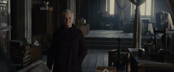 Movie still from “Skyfall” (2012), directed by Sam Mendes – An older woman standing in a dark room; Medium shot, Low angle