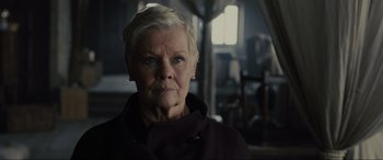 Movie still from “Skyfall” (2012), directed by Sam Mendes – An older woman with short blonde hair wearing a black jacket; Close Up shot, Low angle