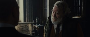 Movie still from “Skyfall” (2012), directed by Sam Mendes – An old man with a beard and a tie; Close Up shot, Over the shoulder angle