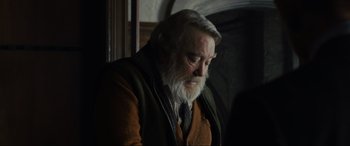 Movie still from “Skyfall” (2012), directed by Sam Mendes – An older man with a beard and a jacket; Close Up shot, Over the shoulder angle