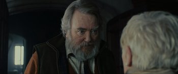 Movie still from “Skyfall” (2012), directed by Sam Mendes – An older man with a beard and a mustache; Close Up shot, Over the shoulder angle