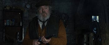 Movie still from “Skyfall” (2012), directed by Sam Mendes – An old man holding a gun in his hands; Close Up shot, Over the shoulder angle
