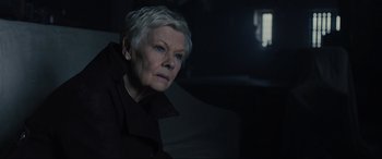 Movie still from “Skyfall” (2012), directed by Sam Mendes – An older woman with short white hair looking at the camera; Close Up shot, Low angle