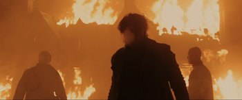 Movie still from “Skyfall” (2012), directed by Sam Mendes – A person standing in front of a fire; Medium shot, Low angle