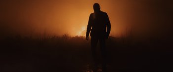 Movie still from “Skyfall” (2012), directed by Sam Mendes – A man standing in the middle of a field at night; Wide shot, Low angle