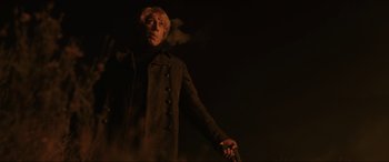 Movie still from “Skyfall” (2012), directed by Sam Mendes – A man holding a gun while standing in the dark; Medium shot, Low angle