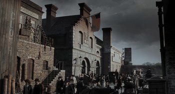 Movie still from “Sleepy Hollow” (1999), directed by Tim Burton – A group of people standing outside of a brick building; Extreme Wide shot, Low angle
