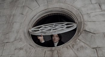 Movie still from “Sleepy Hollow” (1999), directed by Tim Burton – A man in black jacket looking out of a window; Medium shot, Low angle