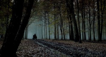 Movie still from “Sleepy Hollow” (1999), directed by Tim Burton – A person riding a horse drawn carriage through a foggy forest; Extreme Wide shot, Low angle