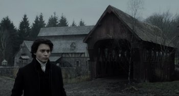 Movie still from “Sleepy Hollow” (1999), directed by Tim Burton – A man standing in front of an old barn; Medium shot, Low angle