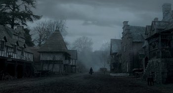 Movie still from “Sleepy Hollow” (1999), directed by Tim Burton – A person walking down a street in a dark city; Extreme Wide shot, High angle