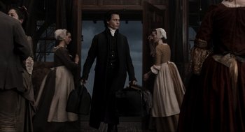 Movie still from “Sleepy Hollow” (1999), directed by Tim Burton – A group of people standing in front of a door; Medium shot, Low angle