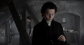 Movie still from “Sleepy Hollow” (1999), directed by Tim Burton – A man in a black jacket looking down at his phone; Medium shot, High angle