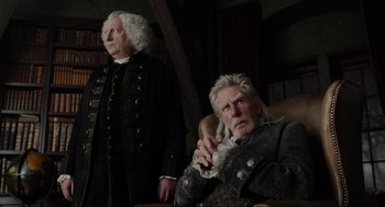 Movie still from “Sleepy Hollow” (1999), directed by Tim Burton – A man with long white hair sitting next to another man with long white hair; Medium shot, Low angle
