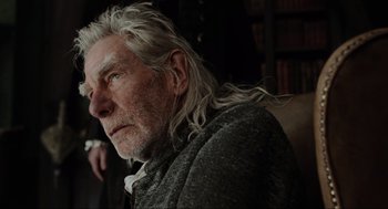 Movie still from “Sleepy Hollow” (1999), directed by Tim Burton – An older man with long white hair sitting in front of a book shelf; Close Up shot, Over the shoulder angle