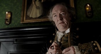 Movie still from “Sleepy Hollow” (1999), directed by Tim Burton – An older man in a victorian outfit holding a bird; Close Up shot, Low angle