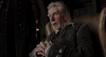 Movie still from “Sleepy Hollow” (1999), directed by Tim Burton – An older man sitting in a chair holding a tissue; Close Up shot, Low angle
