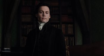 Movie still from “Sleepy Hollow” (1999), directed by Tim Burton – A man in a black coat standing in front of a book shelf; Medium shot, Low angle