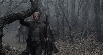 Movie still from “Sleepy Hollow” (1999), directed by Tim Burton – A man holding a rifle in the middle of a forest; Medium shot, Low angle