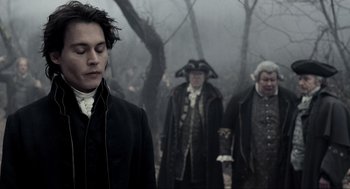 Movie still from “Sleepy Hollow” (1999), directed by Tim Burton – A group of men in period costumes walking through the woods; Medium shot, Over the shoulder angle